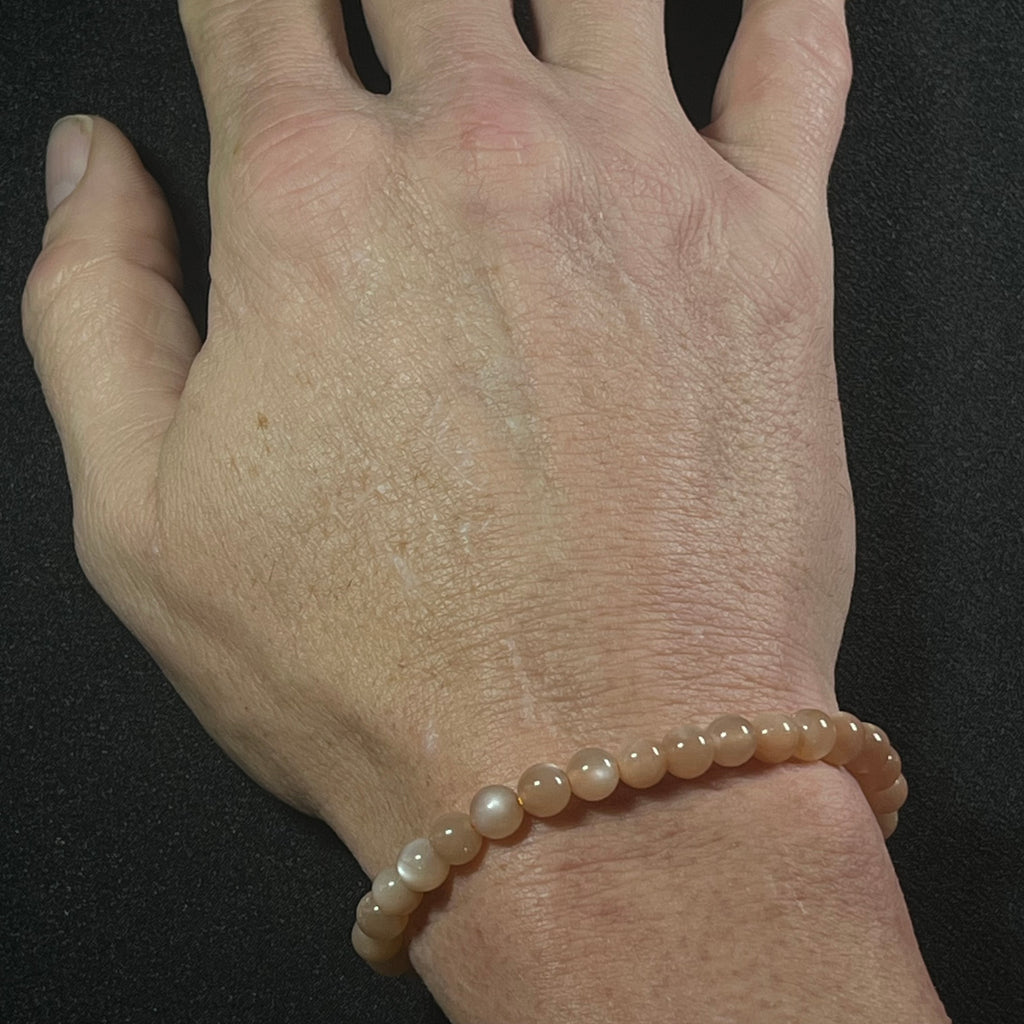 Peach Moonstone (w/ strong flash) smooth round 6mm bead stretch bracelet; June birthstone