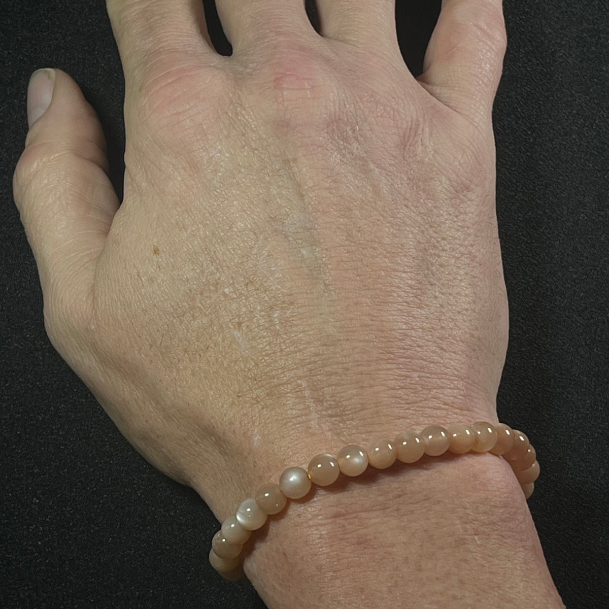 Peach Moonstone (w/ strong flash) smooth round 6mm bead stretch bracelet; June birthstone