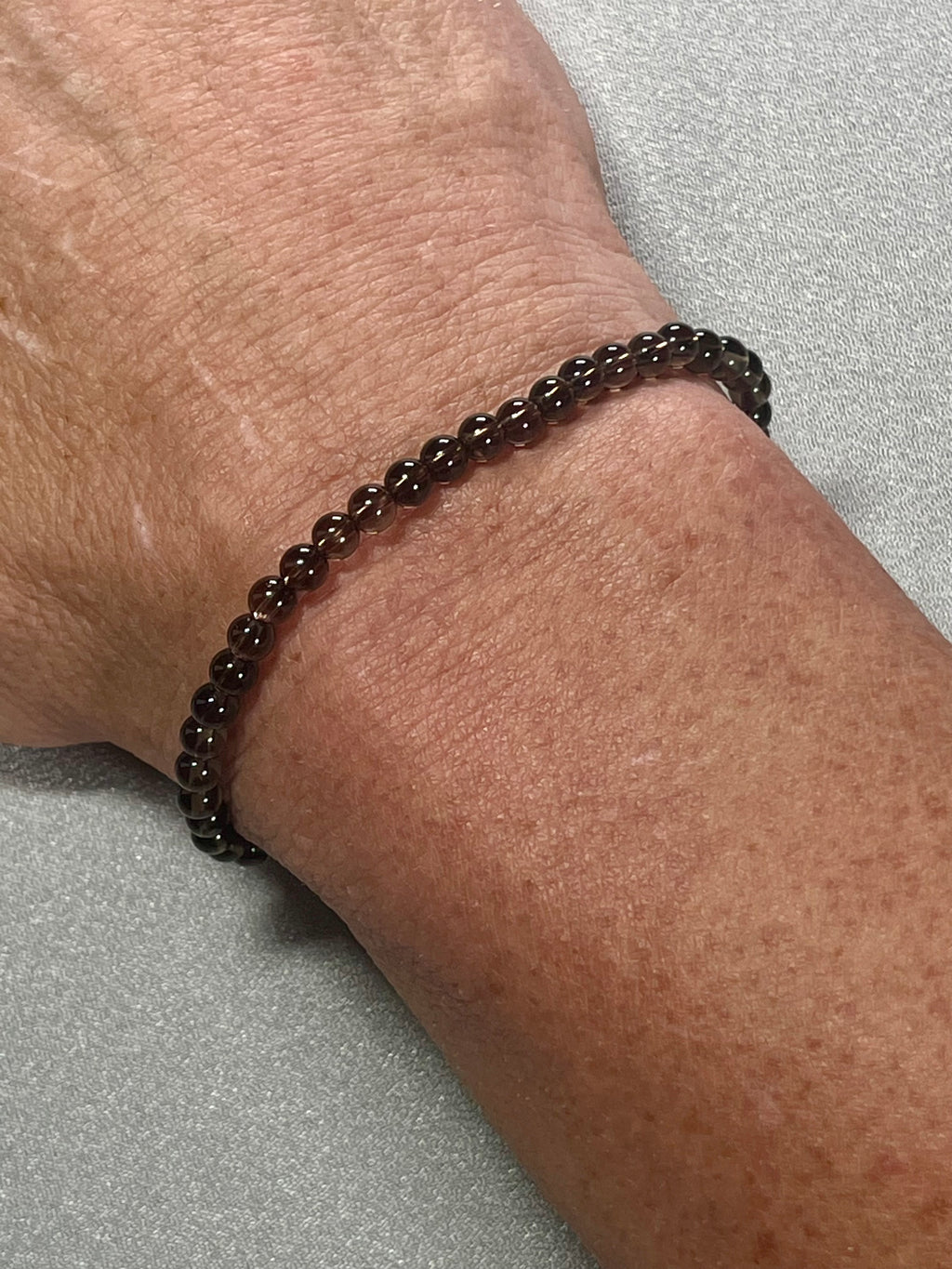 Smoky Quartz smooth round 4mm bead stretch bracelet (premium grade)