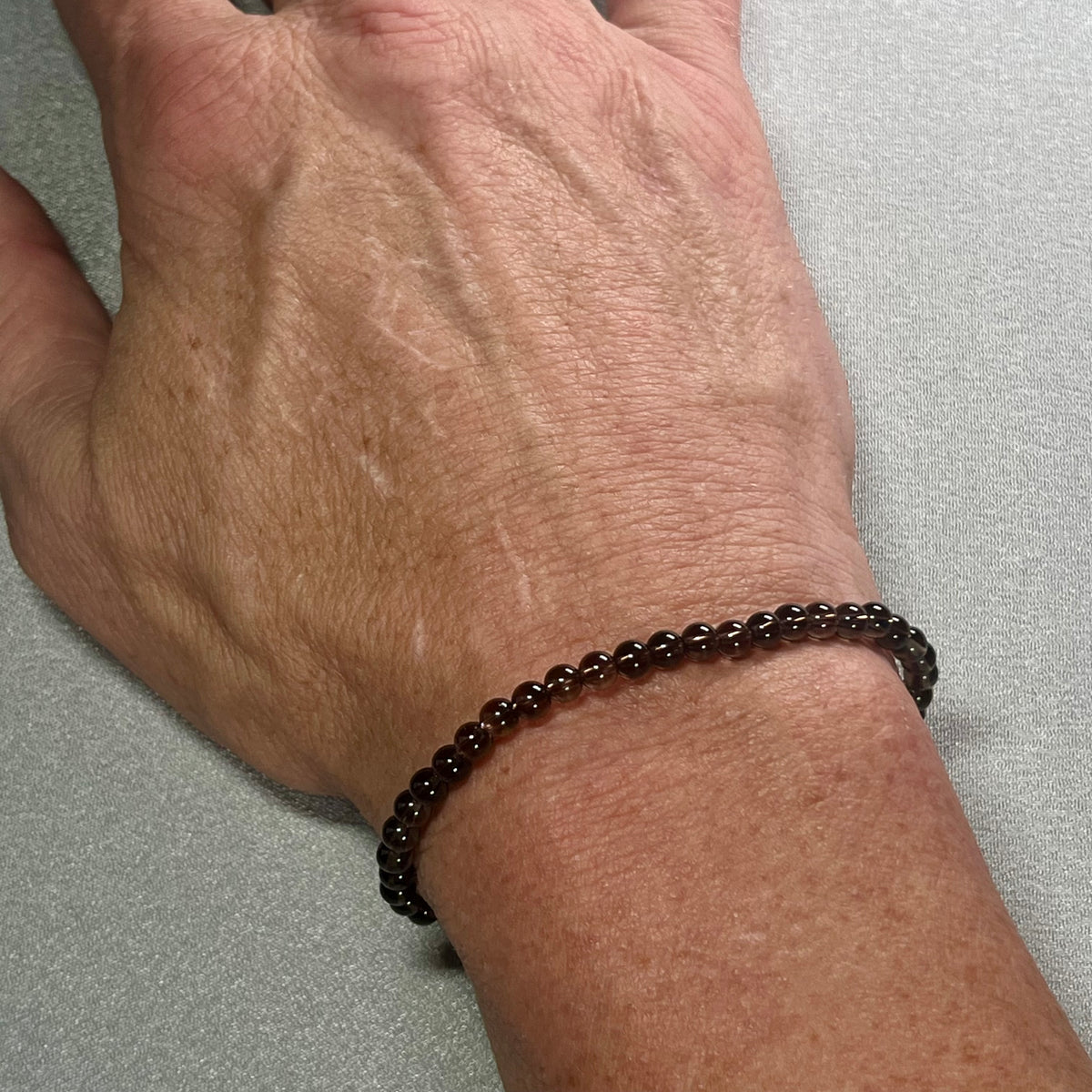 Smoky Quartz smooth round 4mm bead stretch bracelet (premium grade)