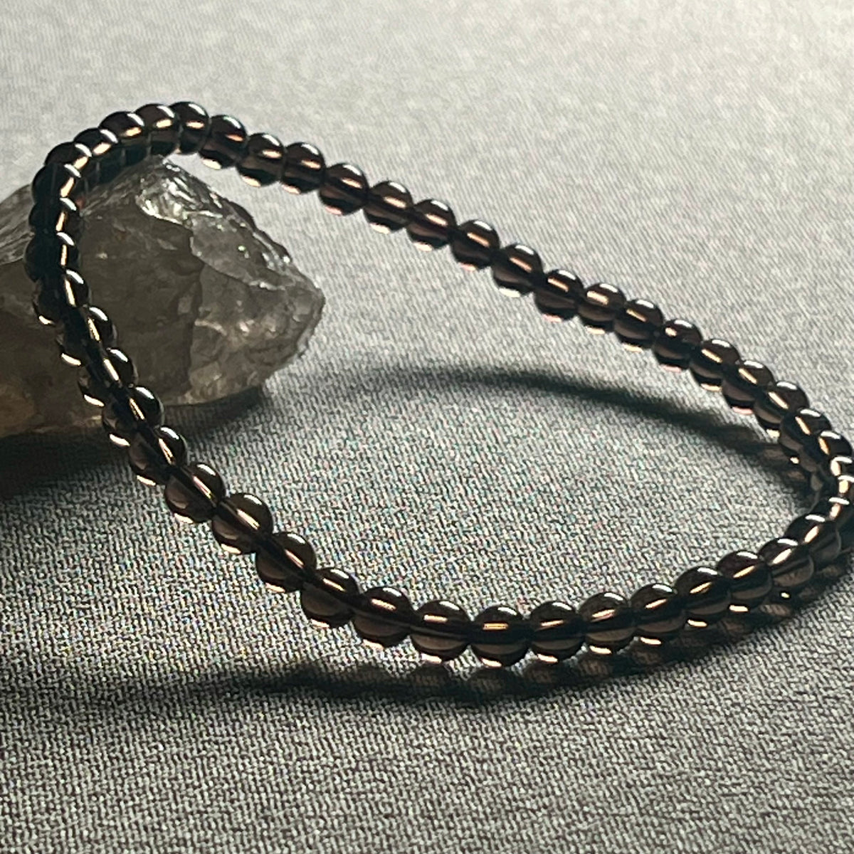 Smoky Quartz smooth round 4mm bead stretch bracelet (premium grade)